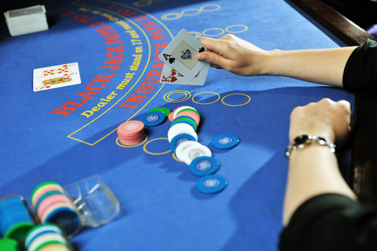 woman play black jack card game in casino